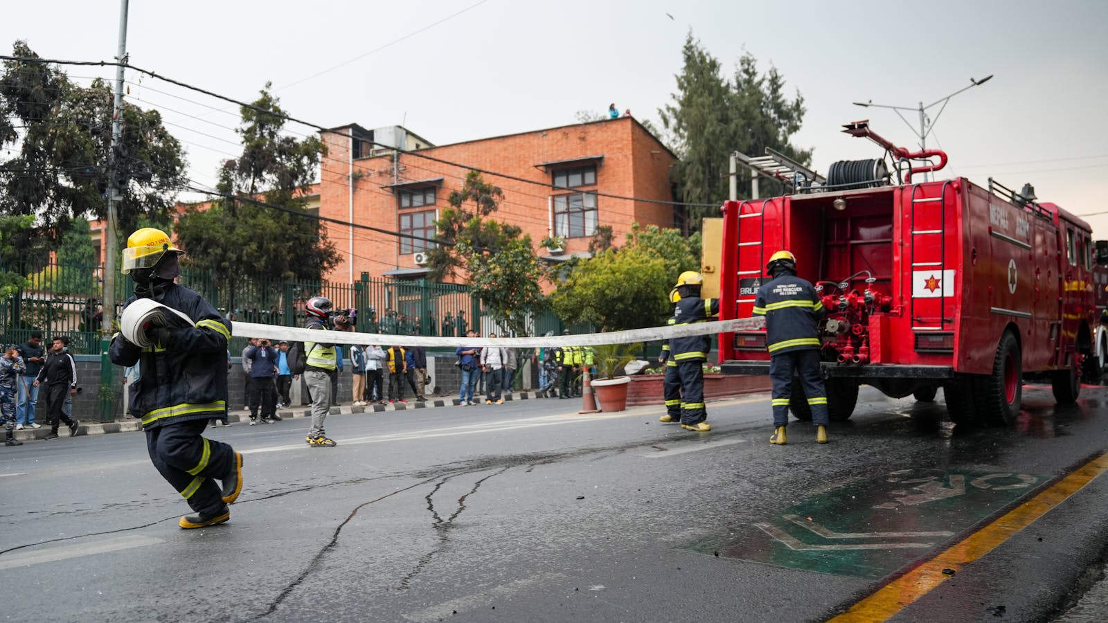 Indian firefighters in action alongside a fire truck
